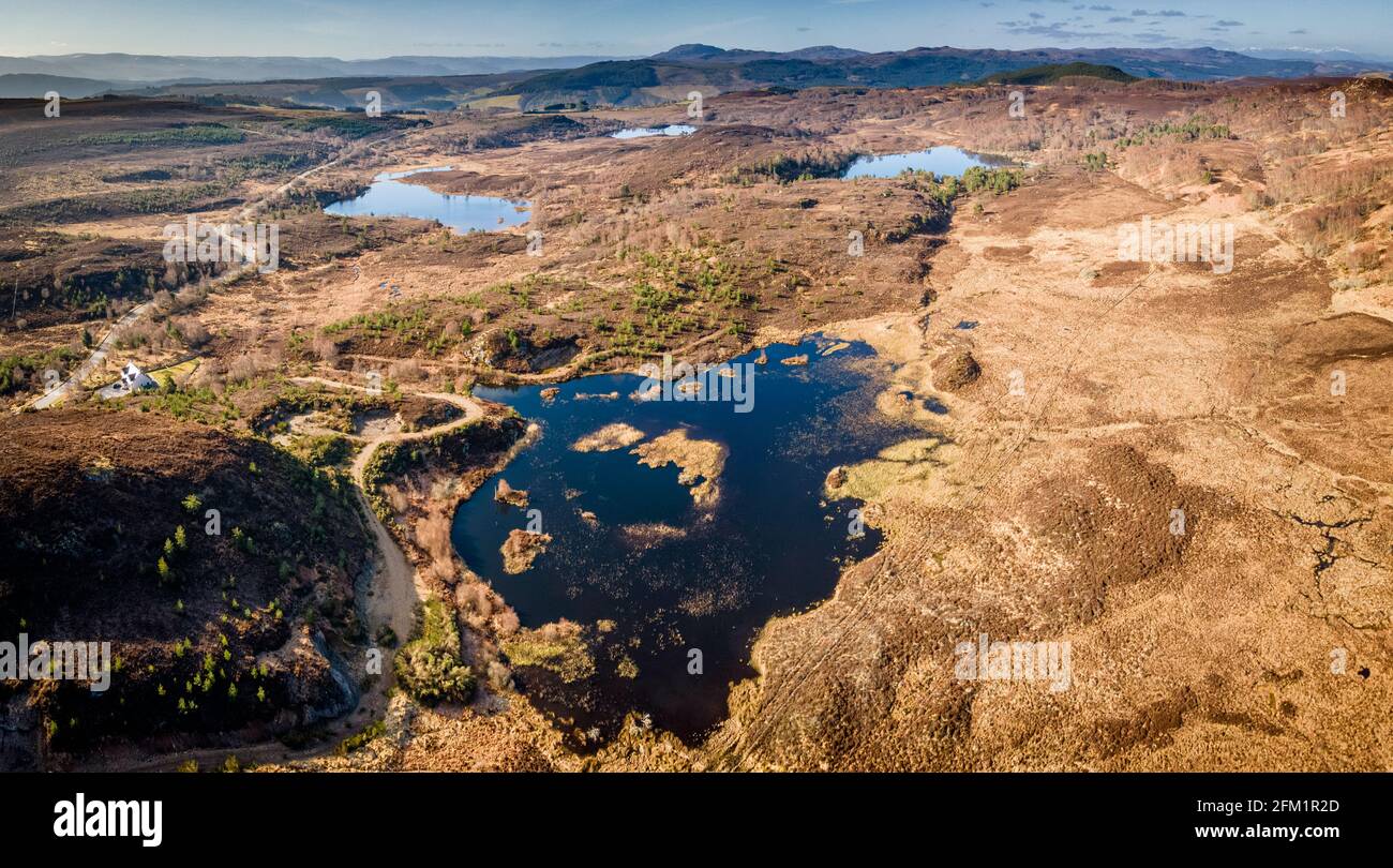 The upland lochs above Glen Urquhart near Drumnadrochit in the Scottish Highlands on a bright spring morning.  Loch nam Bàt (the loch of the boats) is Stock Photo
