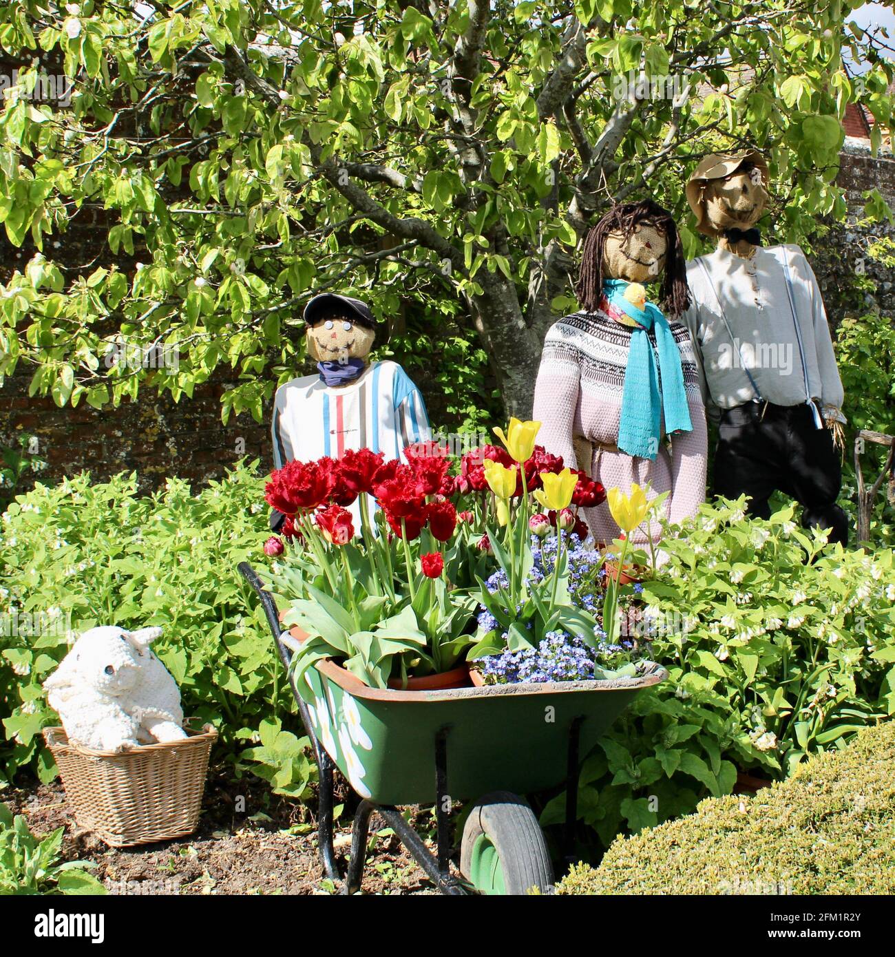 Arundel Castle Tulip Festival - 2021 - A family group of scarecrows greet visitors with their wheelbarrow planted full with tulips. Stock Photo
