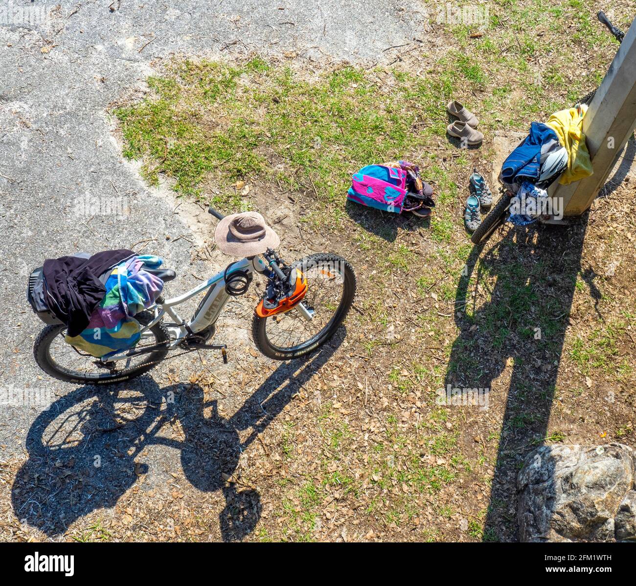 Electric bikes and clothing left by a pole. Stock Photo