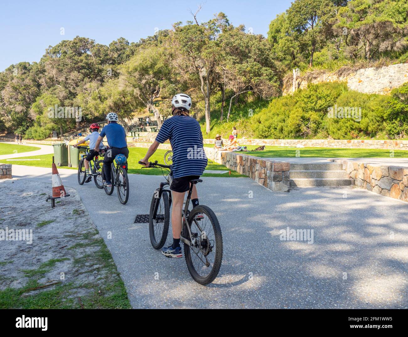 Father and two sons riding their bicycles on a path on Middleton Beach, Ellen Cove, Albany Western Australia. Stock Photo