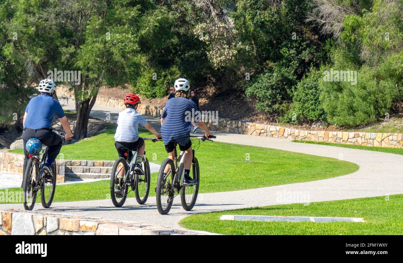 Father and two sons riding their bicycles on a path on Middleton Beach, Ellen Cove, Albany Western Australia. Stock Photo