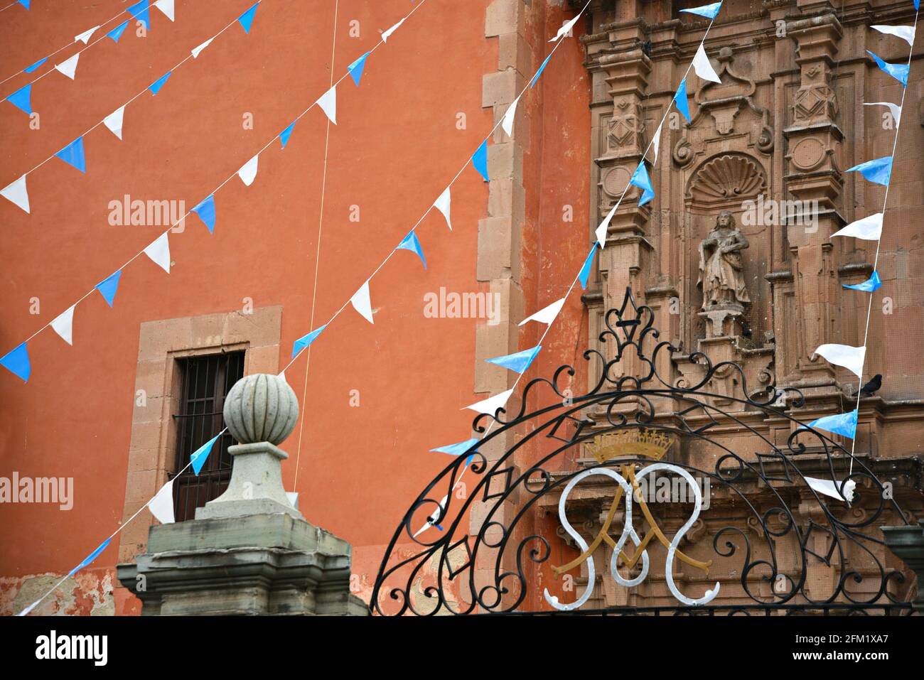 Scenic exterior view of the Baroque style Parroquia del Inmaculado Corazón de María (Belén) with colorful festival banners in Guanajuato Mexico. Stock Photo