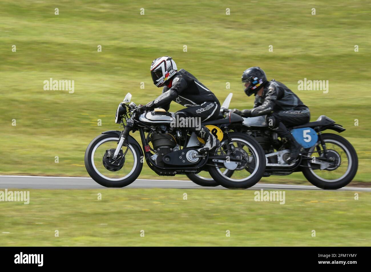 Mike Russell on the 500cc Manx Norton passes Ian Lucas on a 350cc as they approach The Gooseneck at the Cadwell Park International Classic July 2015 Stock Photo