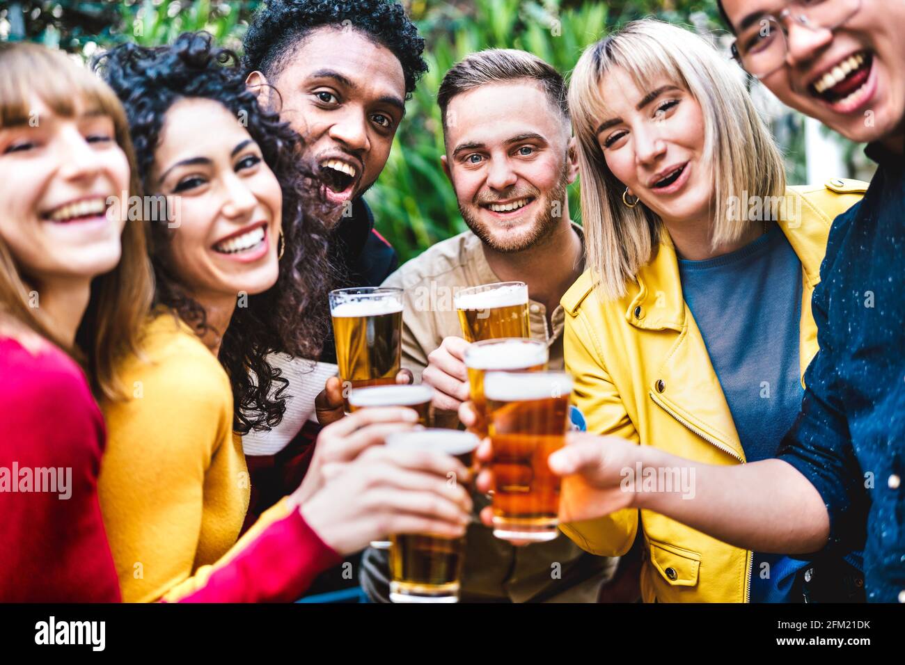 Happy friends toasting beer at brewery bar dehor - Friendship life style concept with young millennial people enjoying time together at open air pub Stock Photo