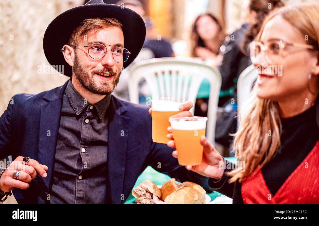 Young couple toasting beer glasses at street food festival - Beverage life style concept with friends having fun together on happy hour at brewery pub Stock Photo