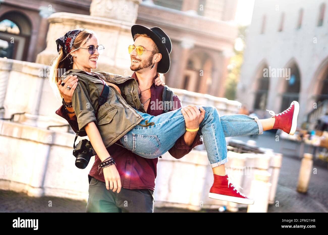 Hipster couple in love having genuine fun wandering at city center - Wanderlust life style and travel vacation concept with guy and girl at old town Stock Photo