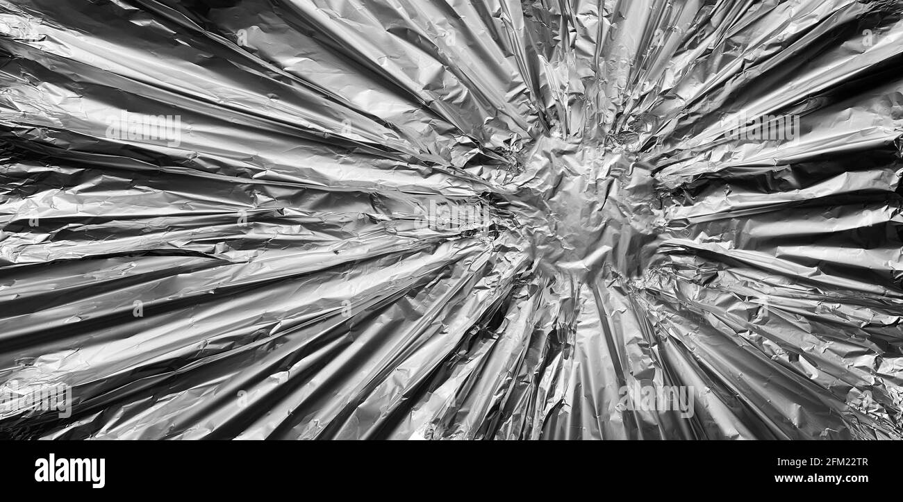 Metal background as a metallic and silver or chrome alloy shaped like a steel banner in a starburst pattern radiating from a center point. Stock Photo