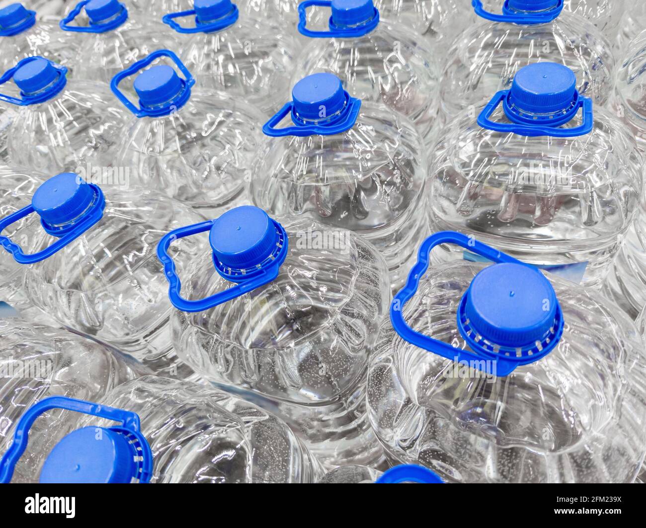full frame background of transparent plastic 5 liter bottles of clear water supplies Stock Photo