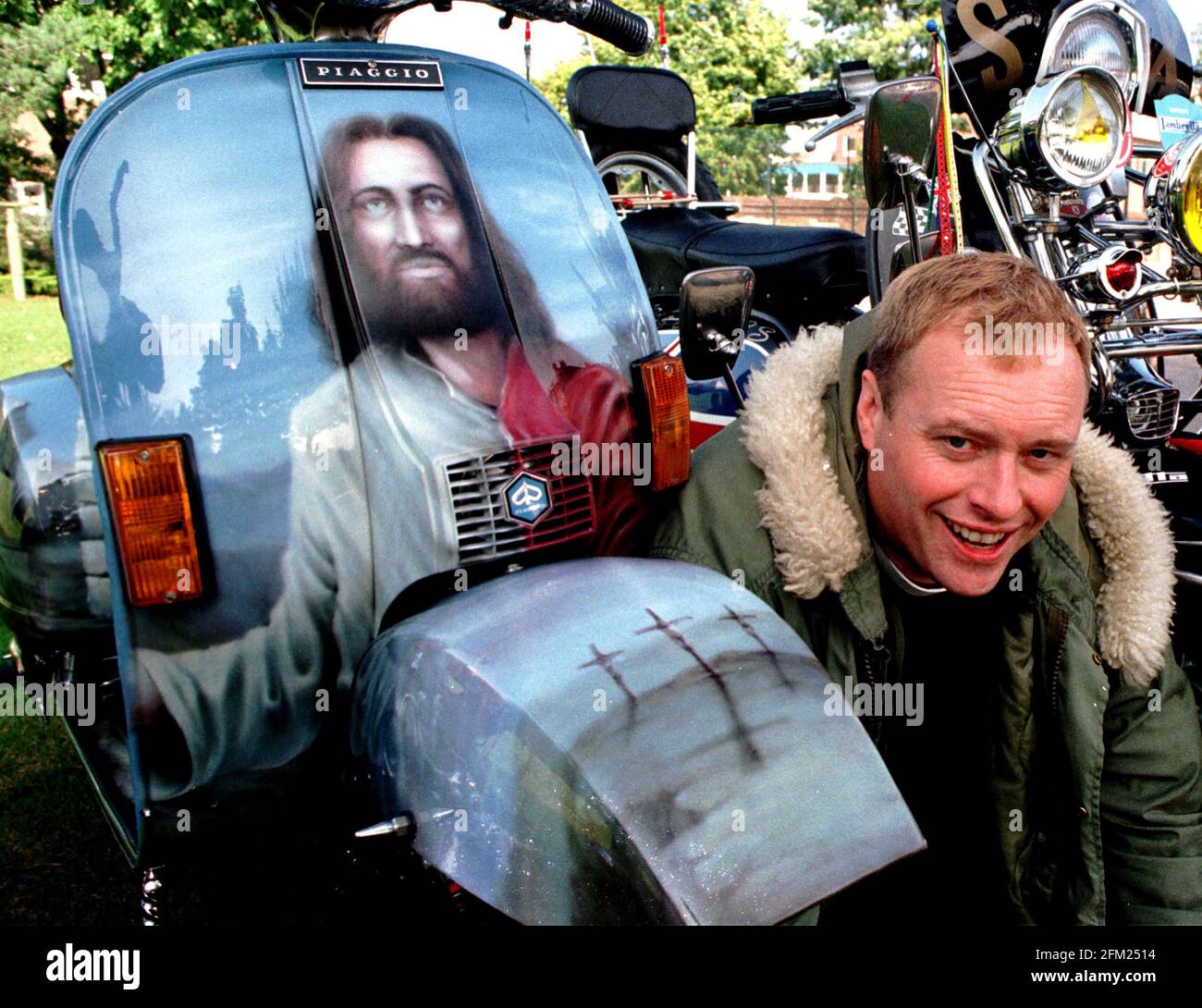 SCOOTER MAD VICAR REV. MIKE BROTHERTON WITH HIS SCOOTER COMPLETE WITH PORTRAIT OF CHRIST AND THE CRUCIFIXION ON THE MUDGUARD, PIC MIKE WALKER, 1998 Stock Photo