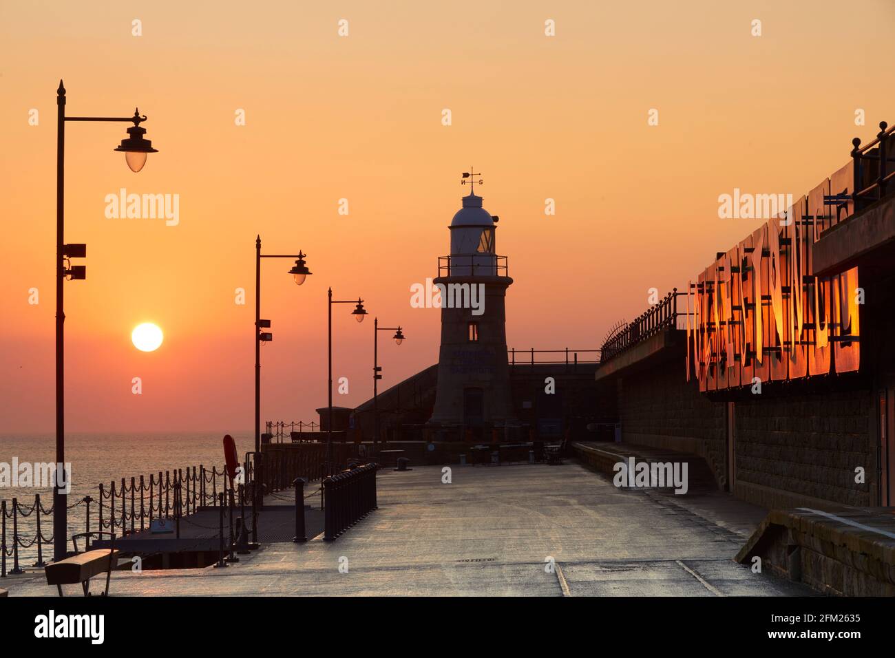 Sunrise over the Harbour Arm and Lighthouse Champagne Bar, Folkestone, Kent, England Stock Photo