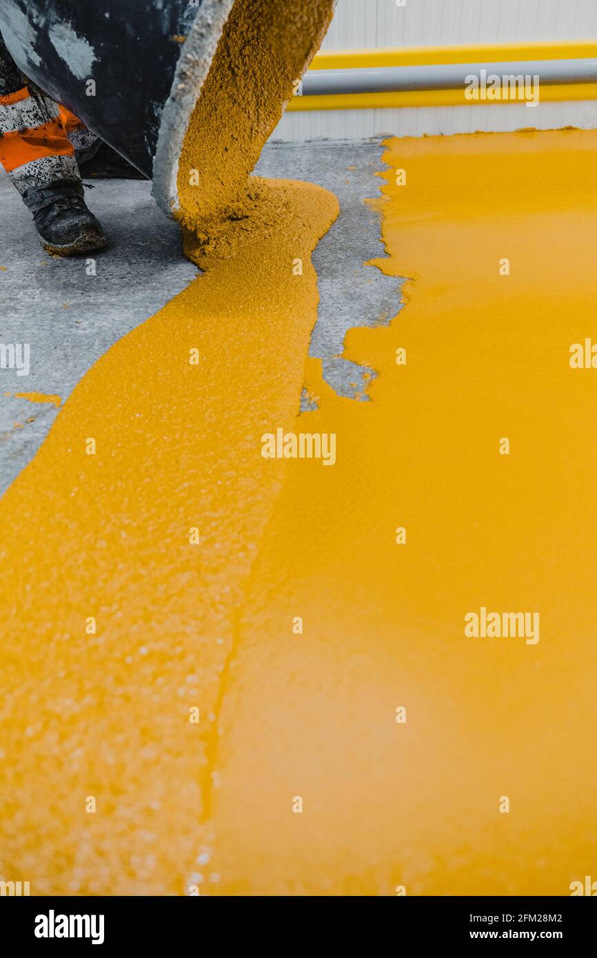 Worker applying epoxy and polyurethane flooring system.These easyto