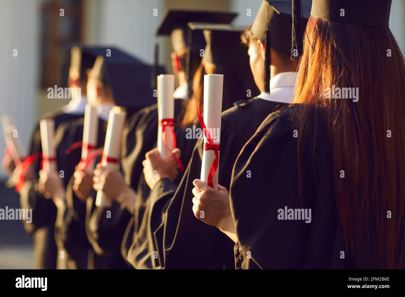 Graduate.Selective focus on graduation student in academic cap and gown hold diploma Stock Photo