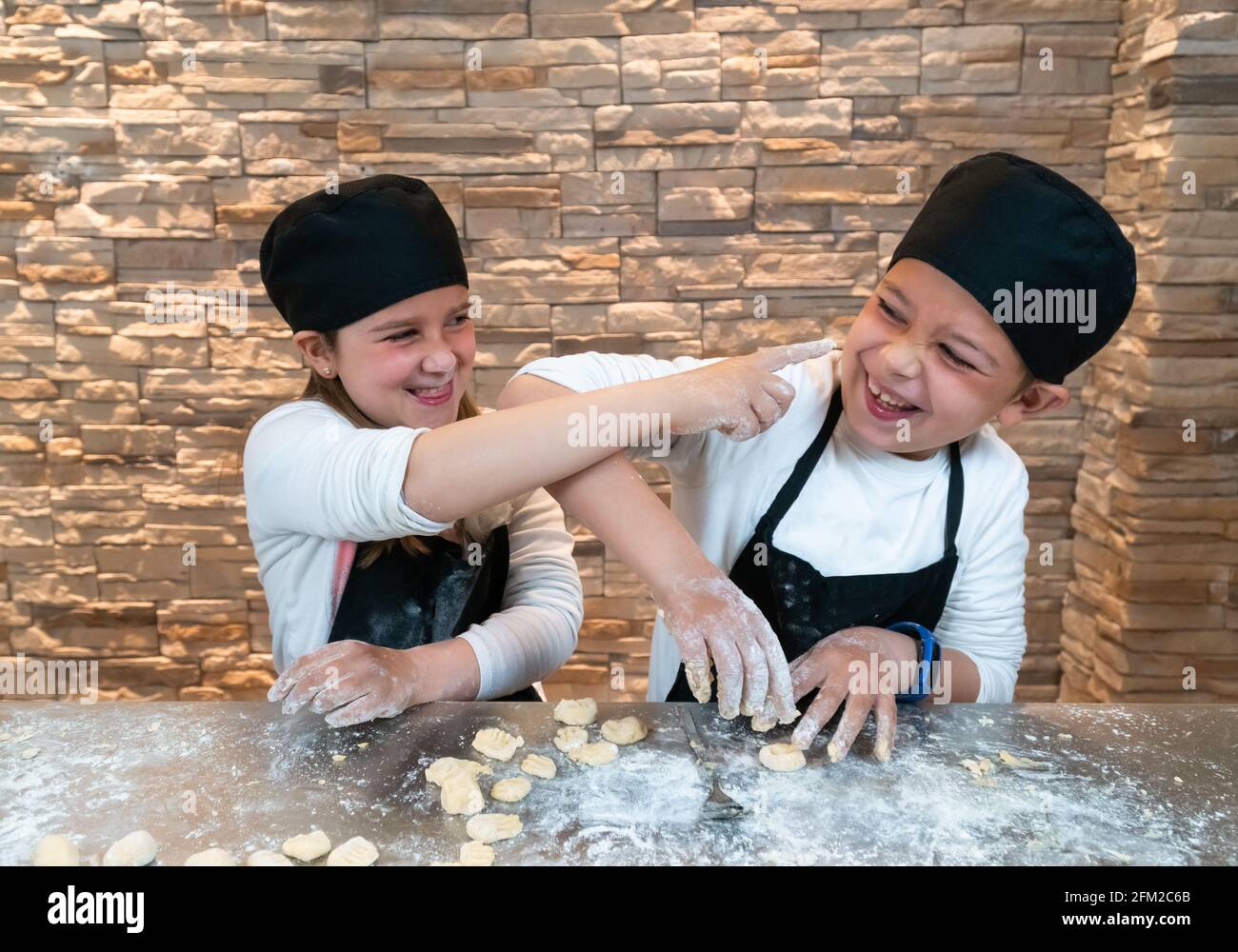 Smiling Kids In Cook's Uniform Making Bakery Dough With Flour And Eggs In  The Kitchen Stock Photo, Picture and Royalty Free Image. Image 60681329.