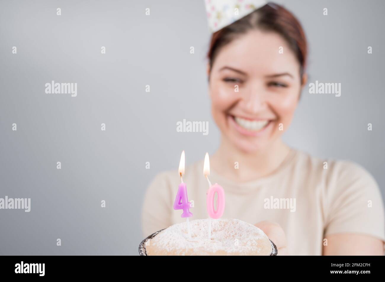 The happy woman makes a wish and blows out the candles on the 40th birthday cake. Girl