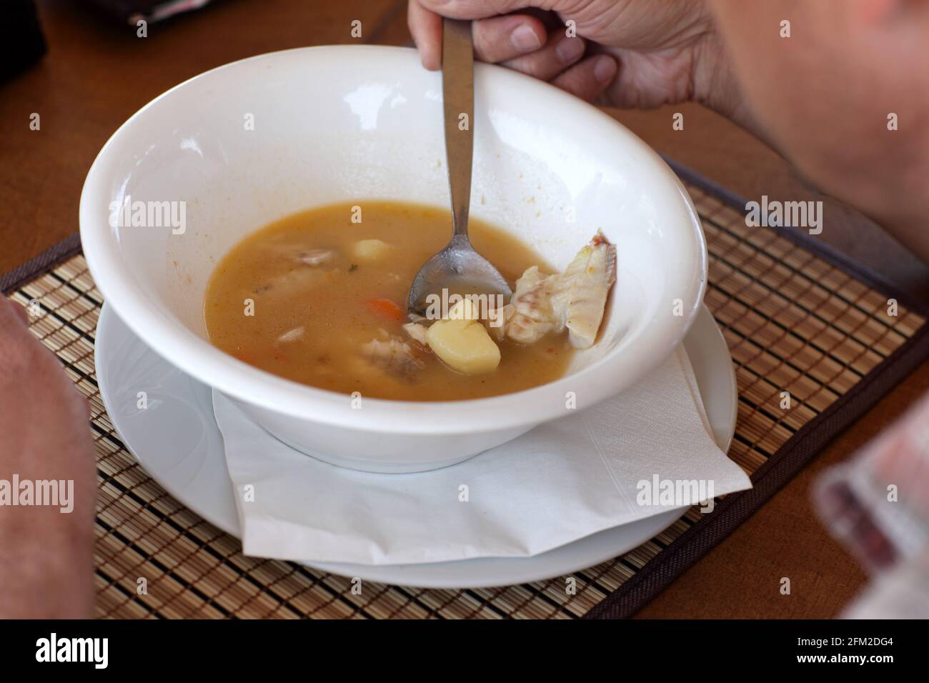 Man is eatign a fish soup in the restaurant Stock Photo
