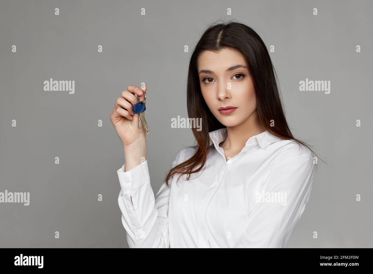 beautiful young brunette woman holding house keys Stock Photo - Alamy