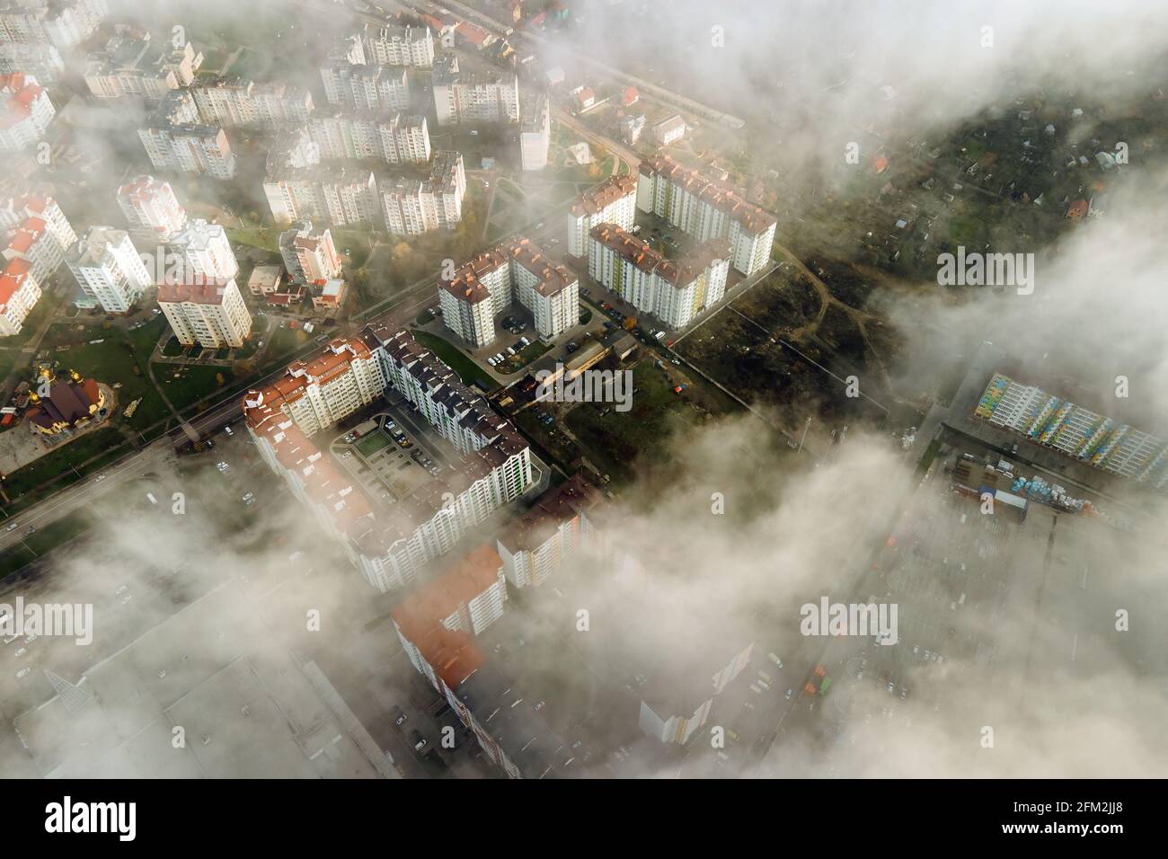 Top aerial view of fluffy white clouds over modern city with high rise ...