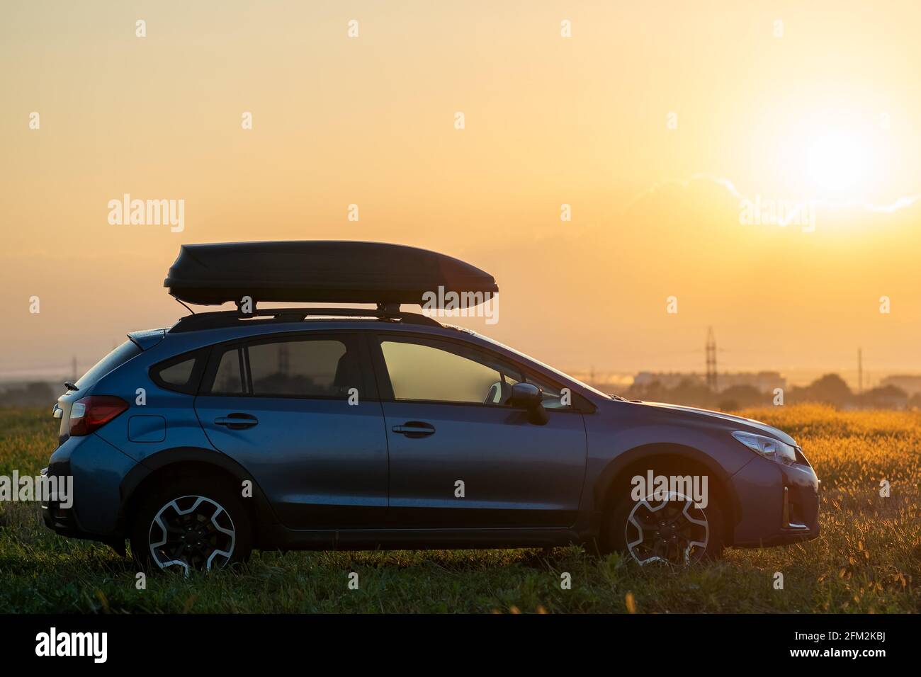 SUV car with roof rack luggage container for off road travelling parked at roadside at sunset. Road trip and getaway concept Stock Photo Alamy