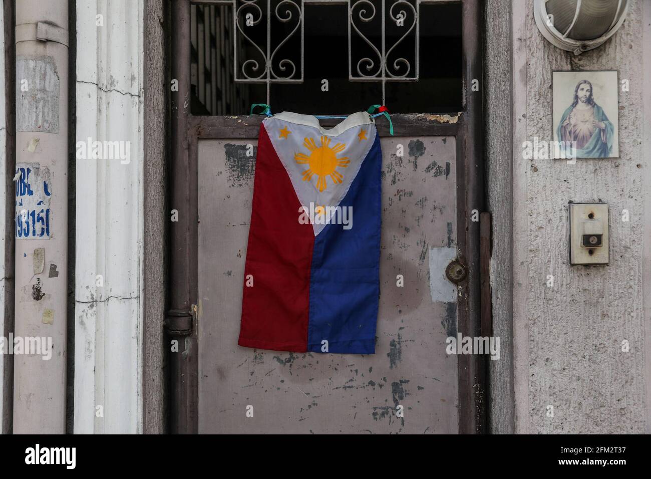 A Philippine flag is seen diplayed on a front door as residents stay in their homes at a condominuim during a coronavirus lockdown in Quezon City, Philippines. Stock Photo