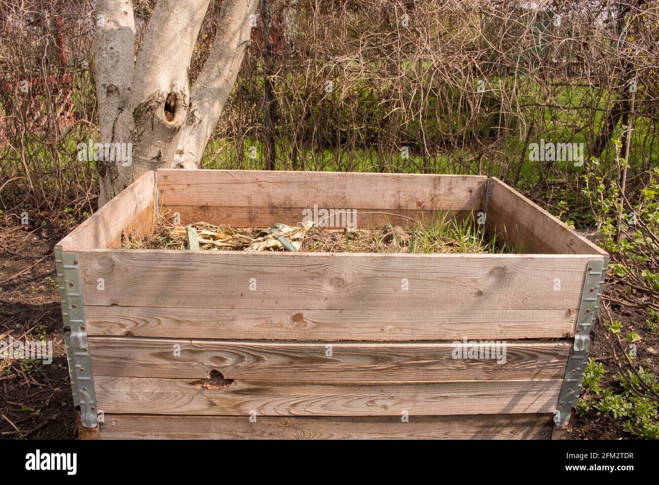 Compost bin in the garden. Composting a pile of rotting kitchen fruit
