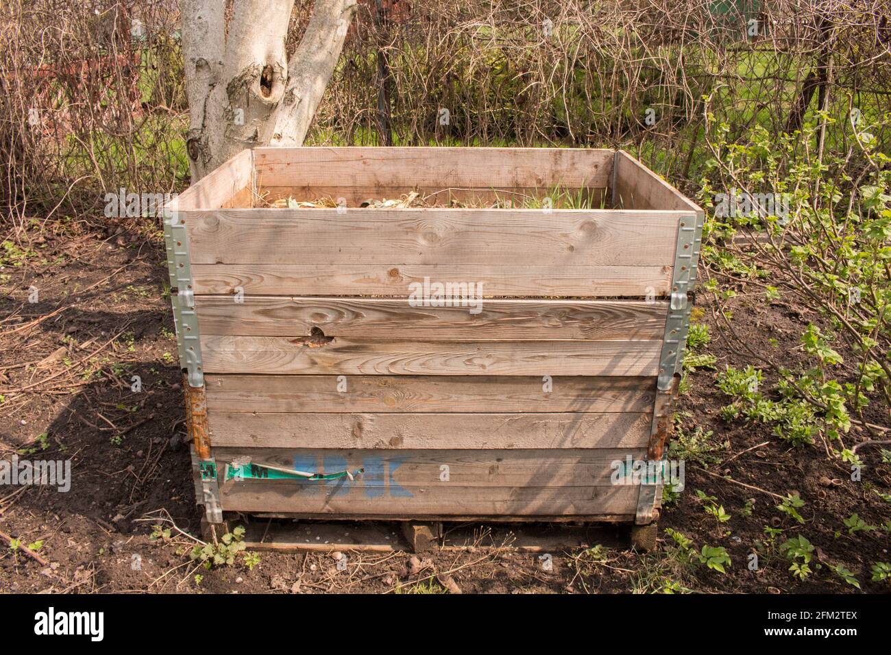 Compost bin in the garden. Composting a pile of rotting kitchen fruit