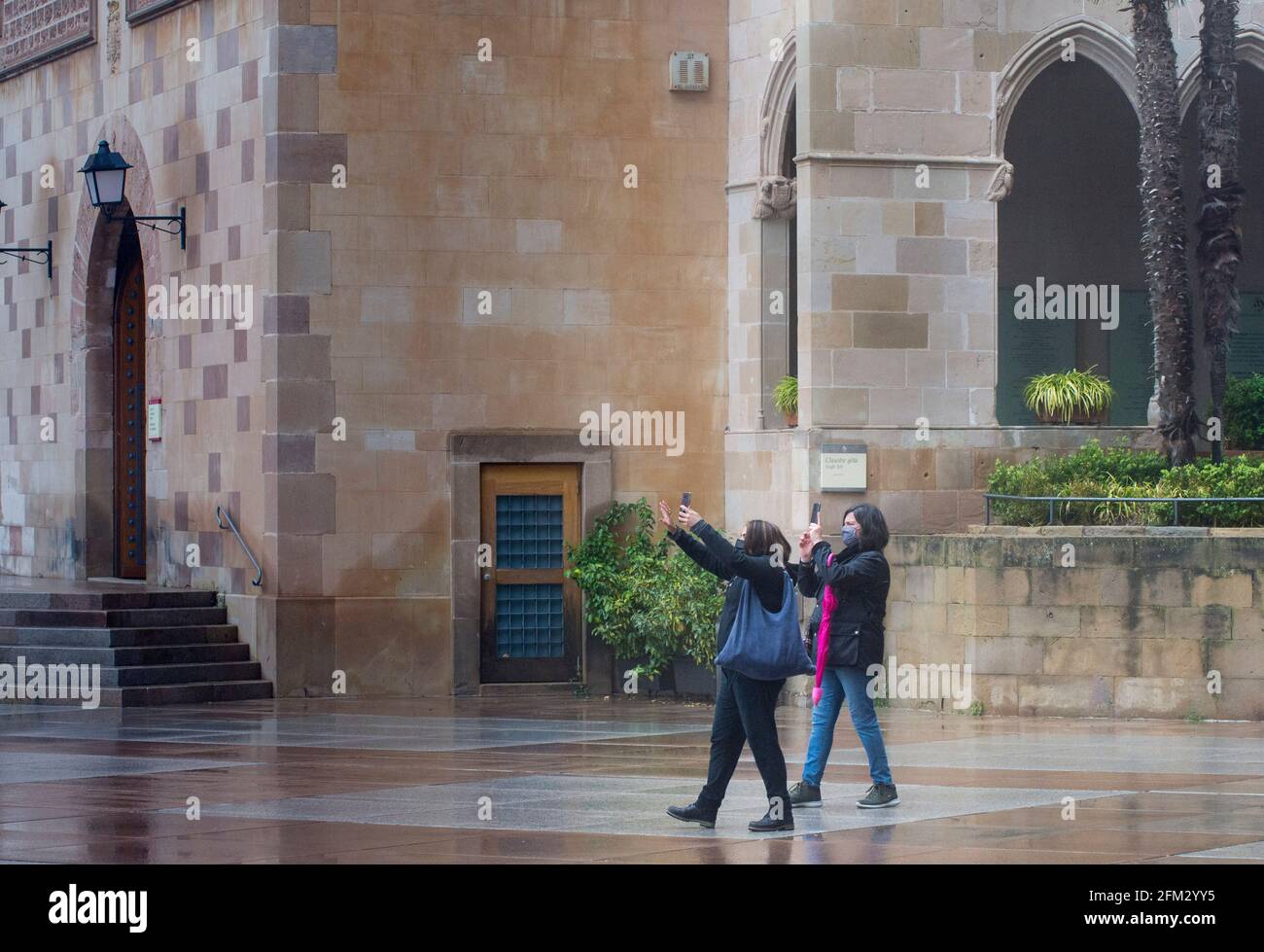 Domestic and International tourists wearing facemarks are visiting the monastery of Montserrat during a misty and rainy spring day, at the end of the pandemic induced Spanish State of Emergency in the Montserrat mountain range, west of Barcelona in the province of Catalonia, Spain. © Olli Geibel Stock Photo