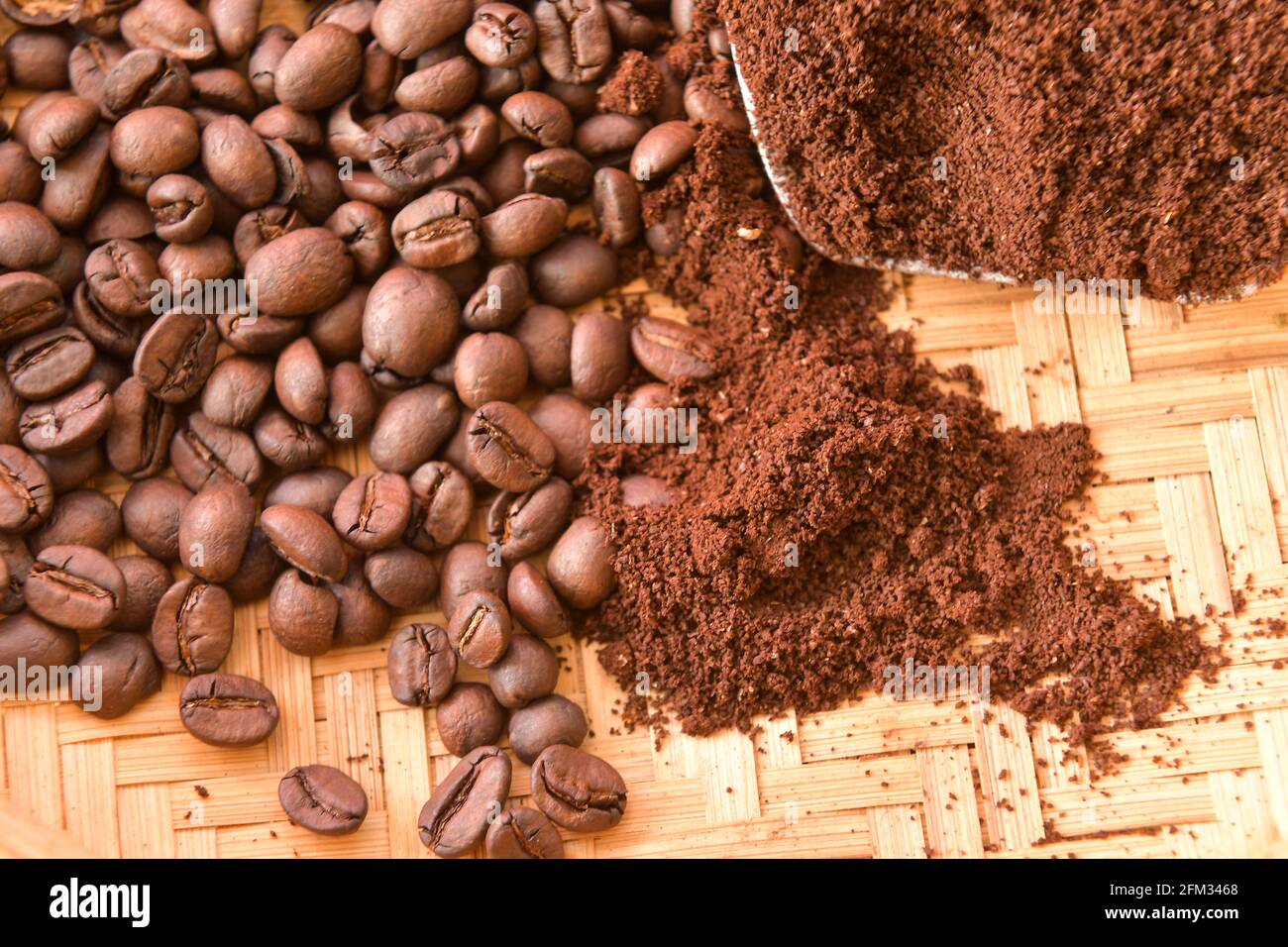 Roasted coffee beans and ground coffee on a bamboo tray Stock Photo