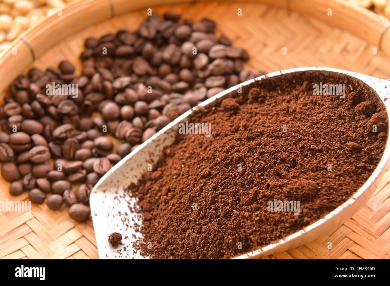 Roasted coffee beans and ground coffee on a bamboo tray Stock Photo