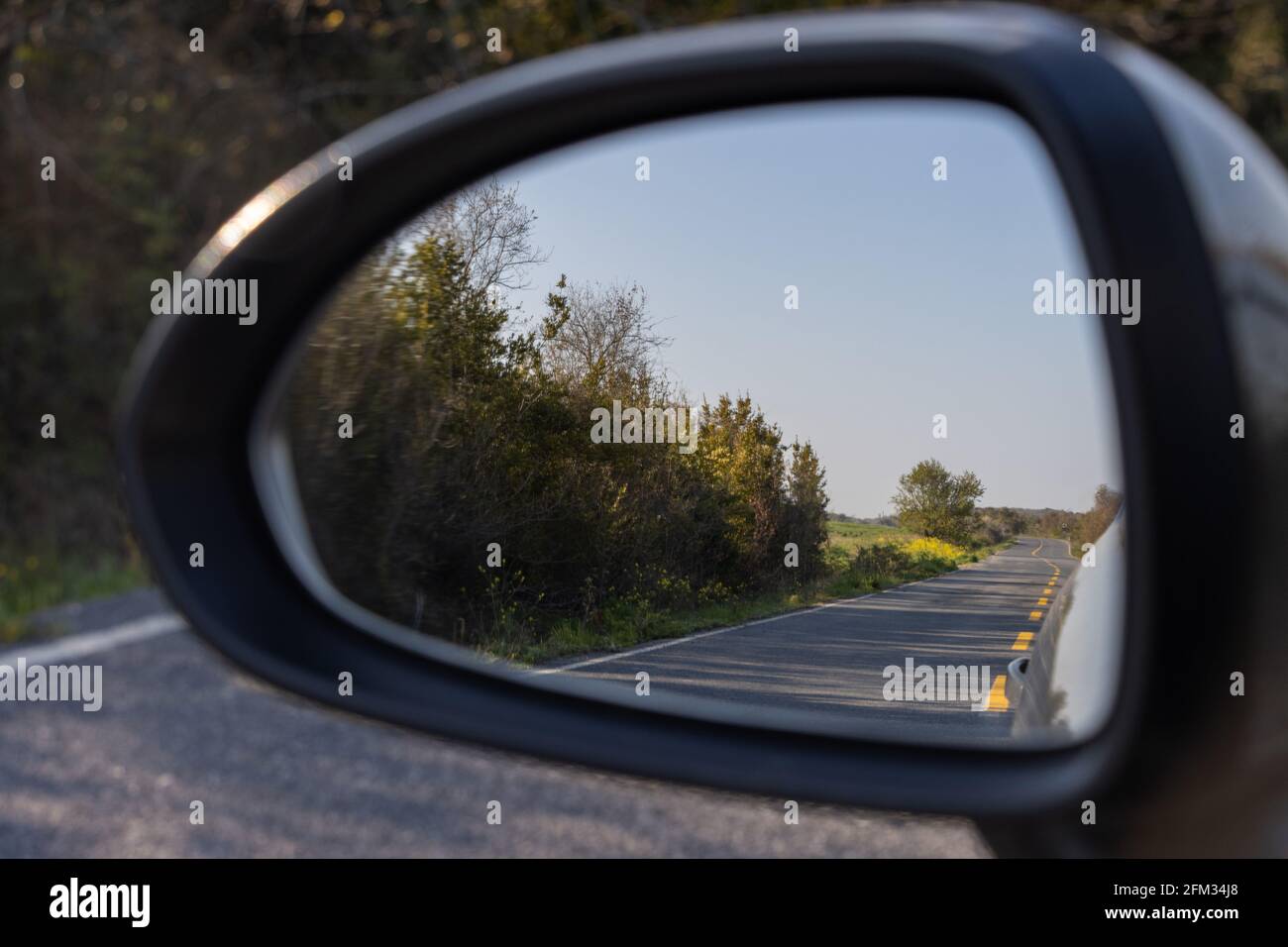 Driving on the forest rural road, view from car mirror Stock Photo