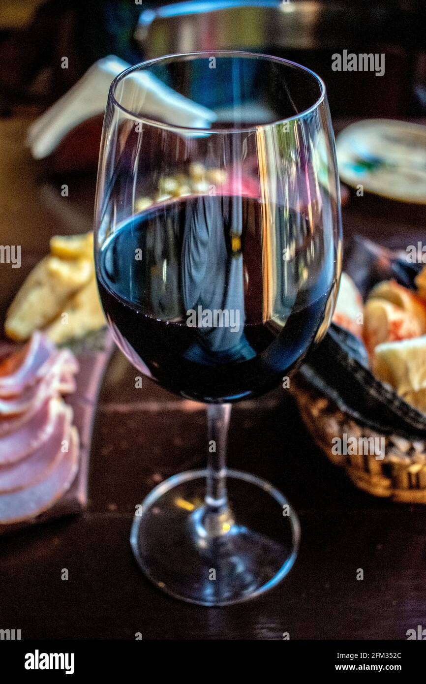 Glass of red wine with cold cuts and cheeses ("picada Stock Photo Alamy