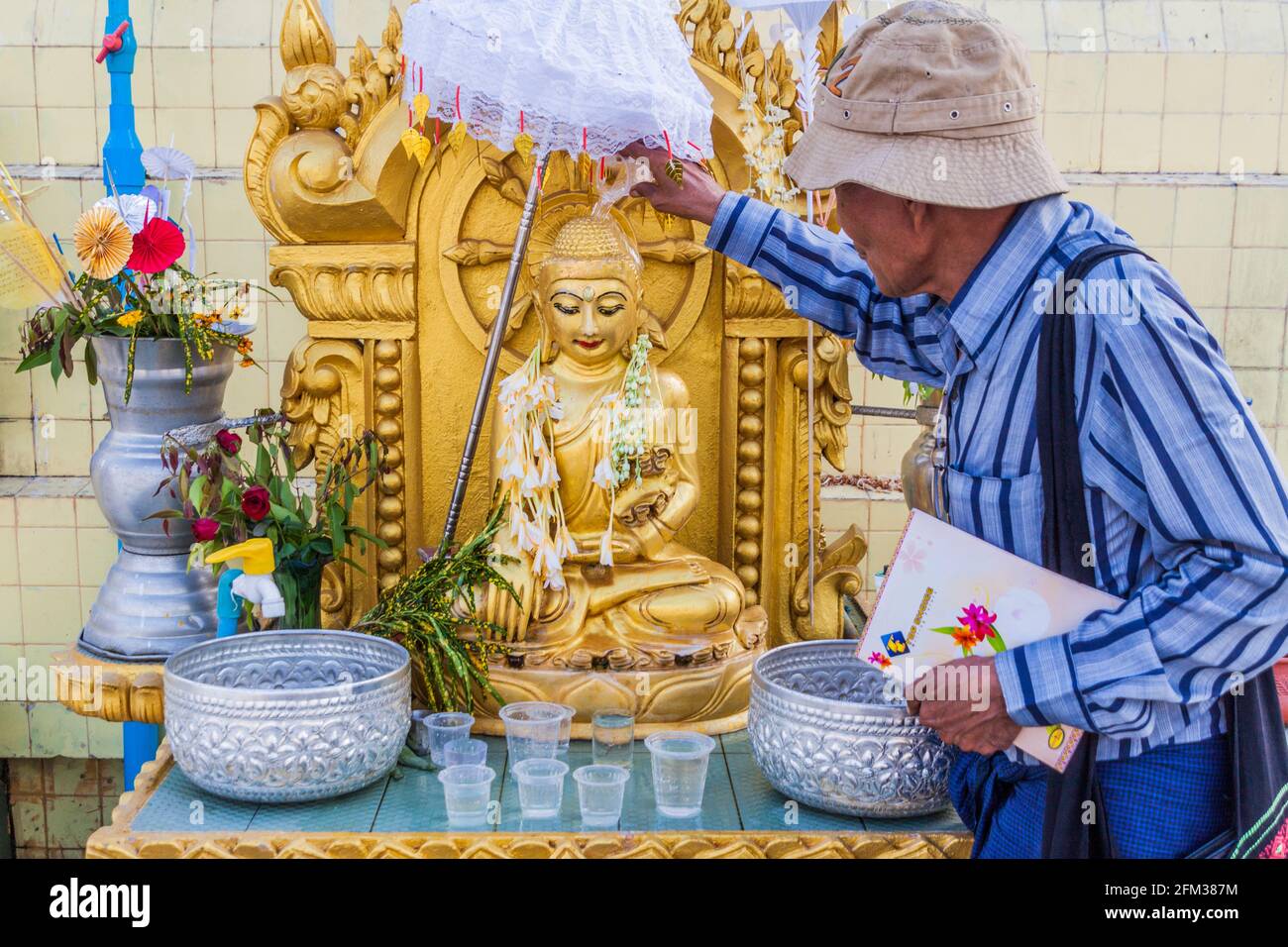 YANGON, MYANMAR - DECEMBER 15, 2016: Local man performing a ritual at Botataung Paya pagoda in Yangon, Maynmar Stock Photo