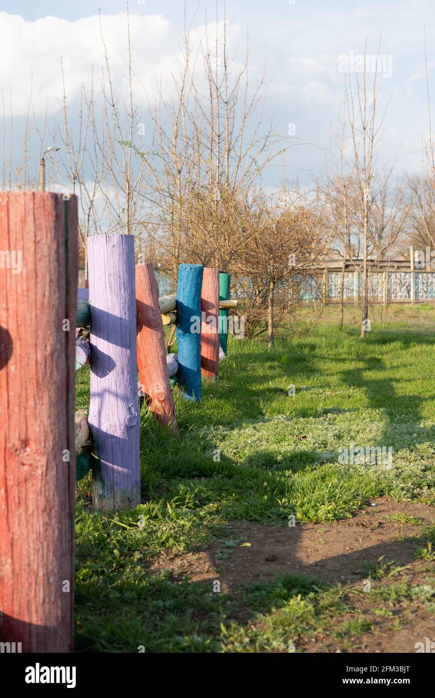 Rustic hedge made of logs of different vibrant colors Stock Photo