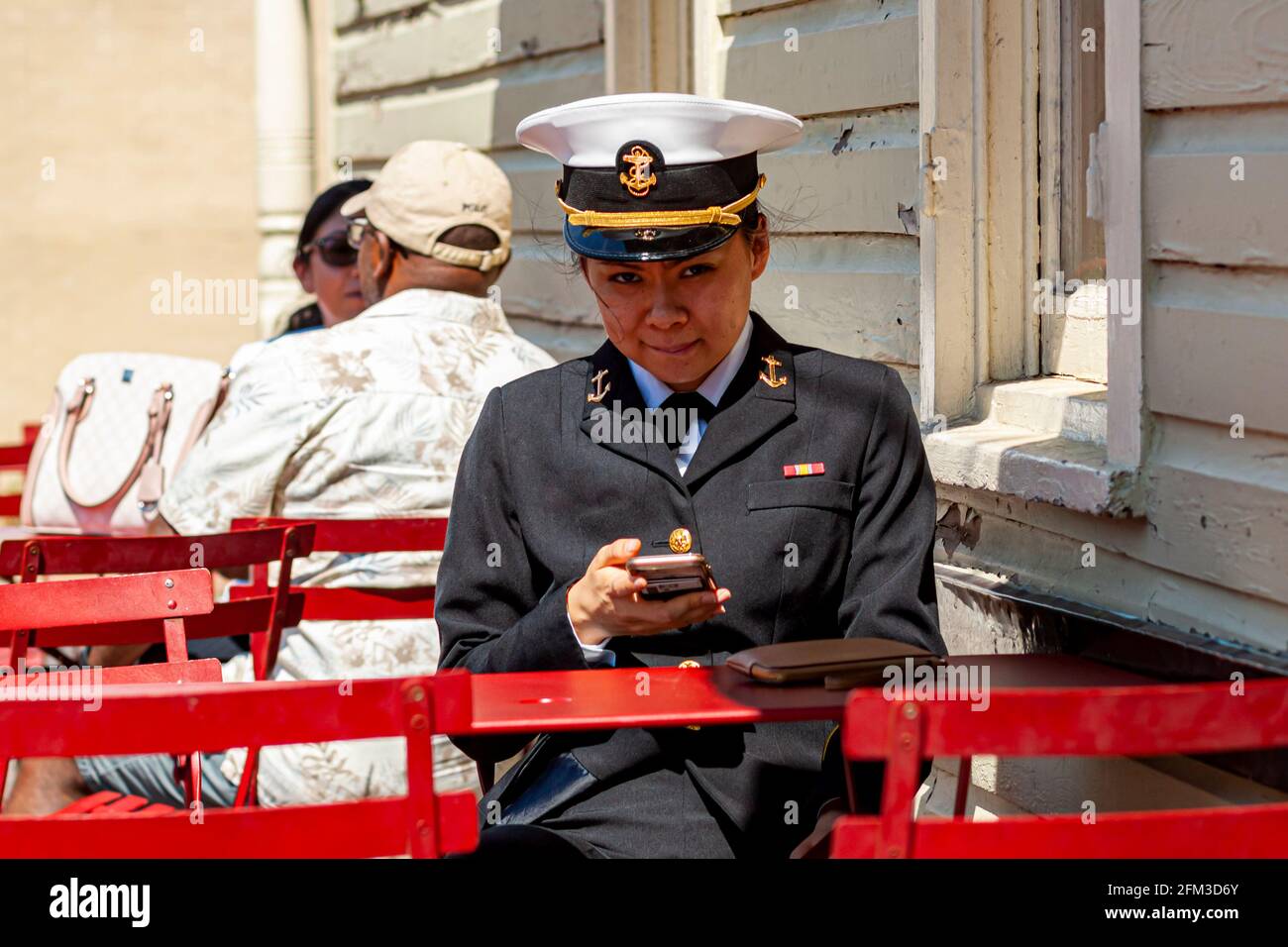 Annapolis, MD, USA 05-02-2021: A young Asian American female cadet training at the US Naval Academy in Annapolis is sitting at a restaurant table with Stock Photo