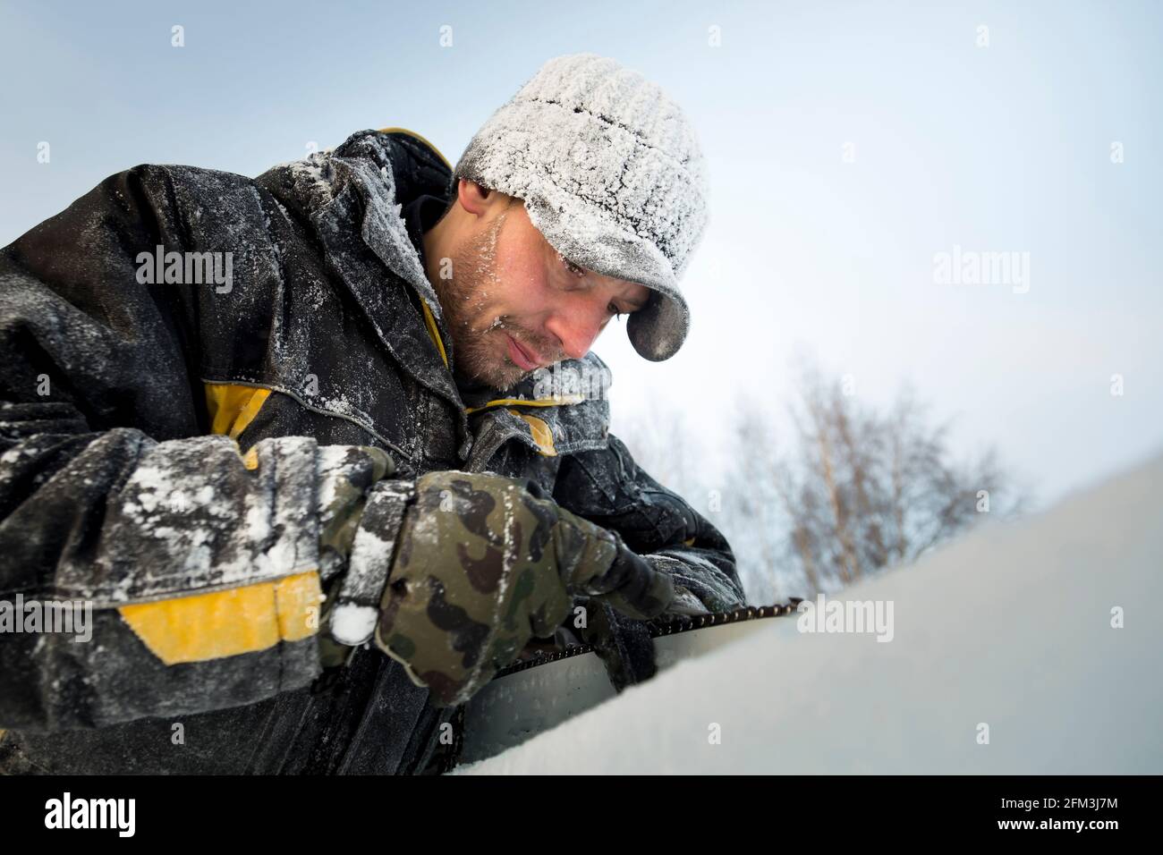 A manual file worker sharpens a chainsaw chain Stock Photo