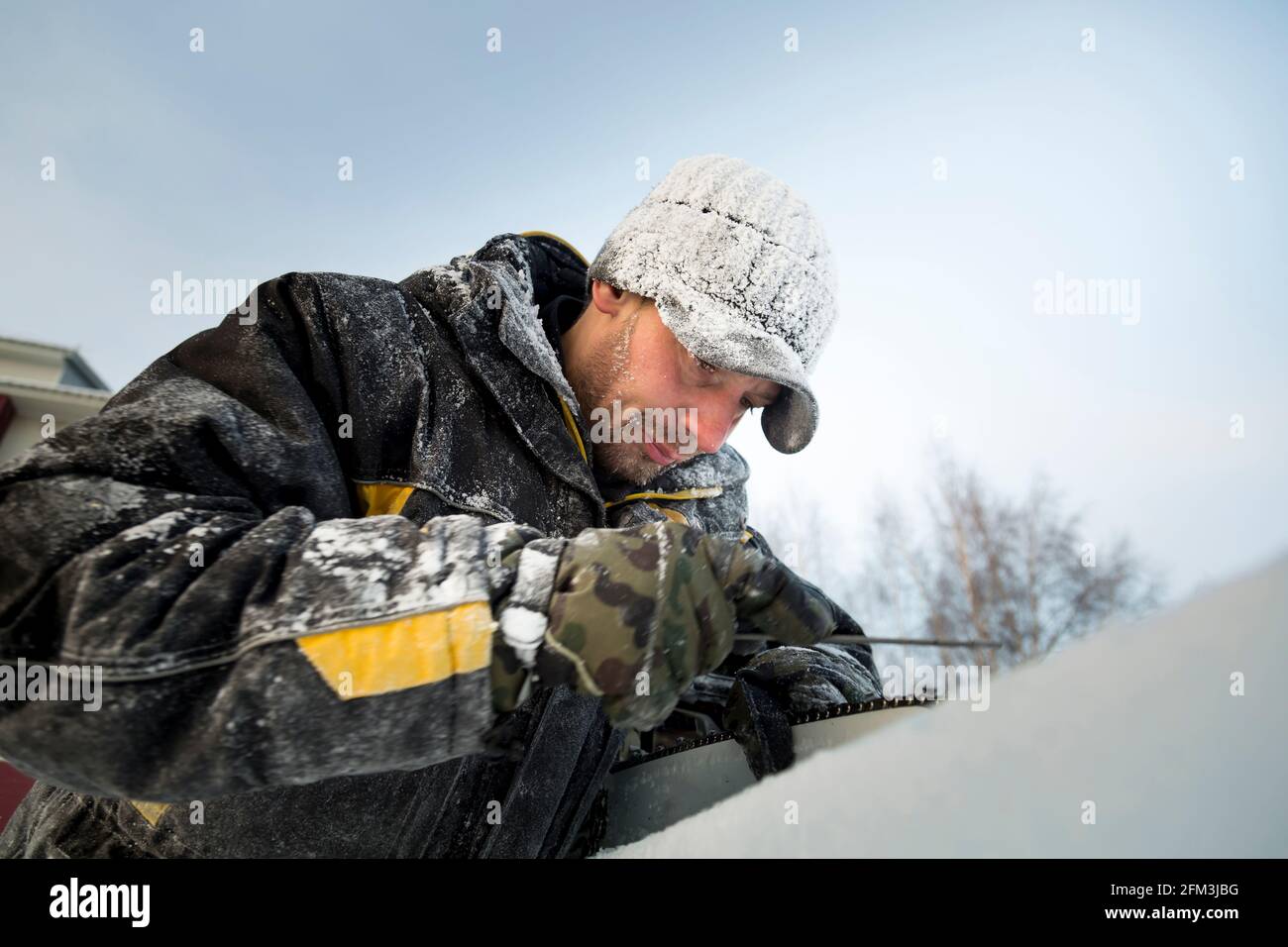 A manual file worker sharpens a chainsaw chain Stock Photo