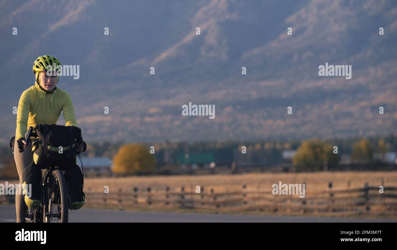 The woman travel on mixed terrain cycle touring with bikepacking. The traveler journey with bicycle bags. Sport tourism bikepacking. Stock Photo