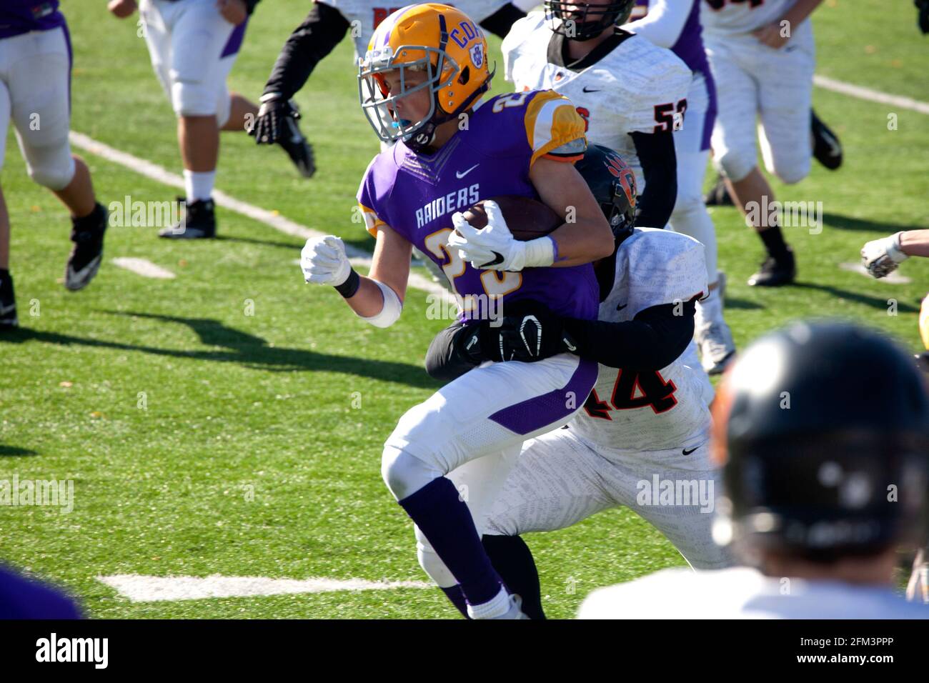 High school football player running with ball while being tackled. St Paul Minnesota MN USA Stock Photo