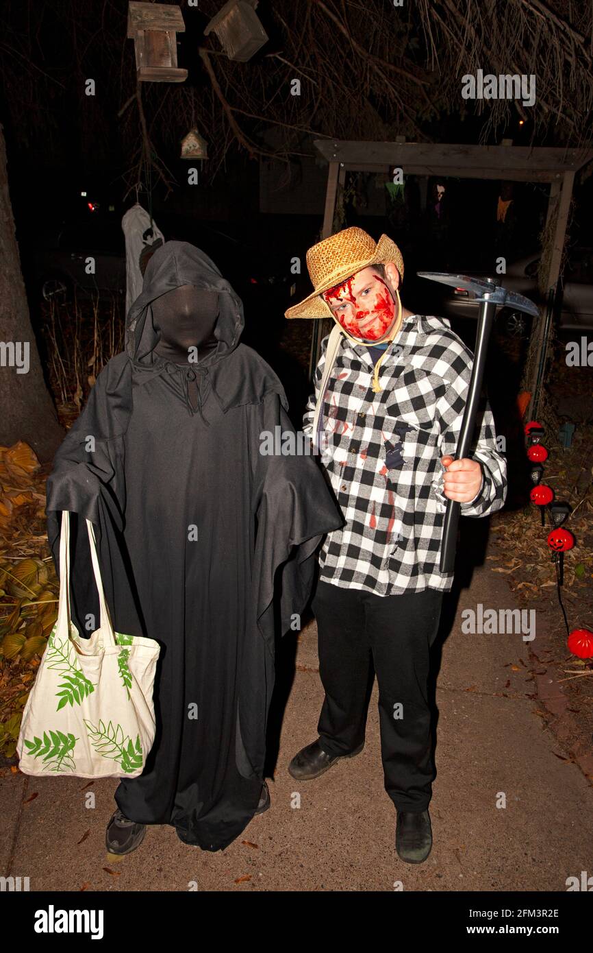 Halloween trick and treaters costumed as a bloody cowboy and walking death. St Paul Minnesota MN USA Stock Photo
