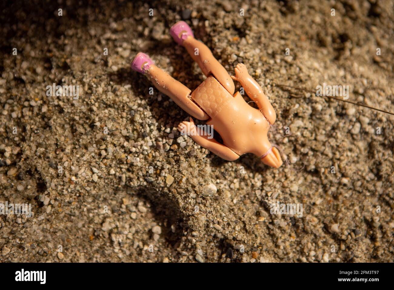 Abandoned Headless Childs Doll in a Sandpit, South Island, New Zealand Stock Photo