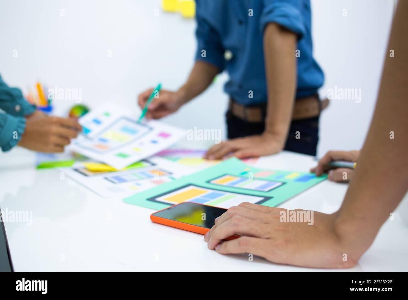team designers Presentation model mobile phone screen to suit their usage.UX UI and Programming Stock Photo