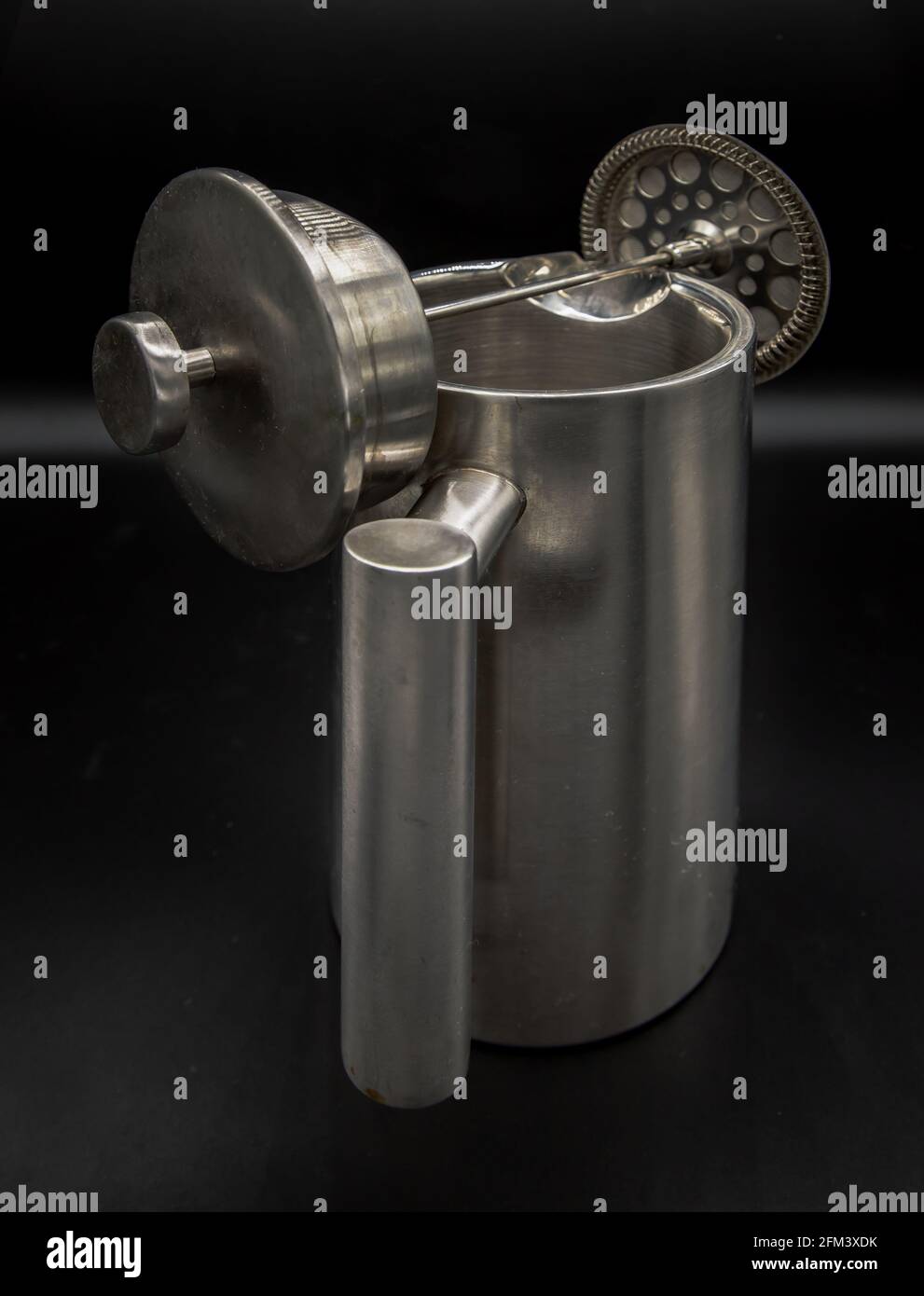 Cafetiere plunger is placed on stainless steel jug with black