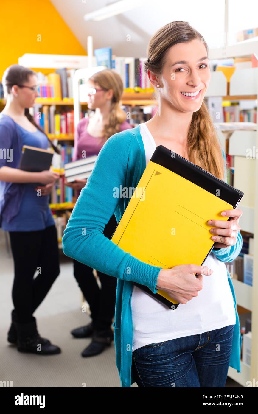 Student - young woman or girl with books in library learning Stock ...