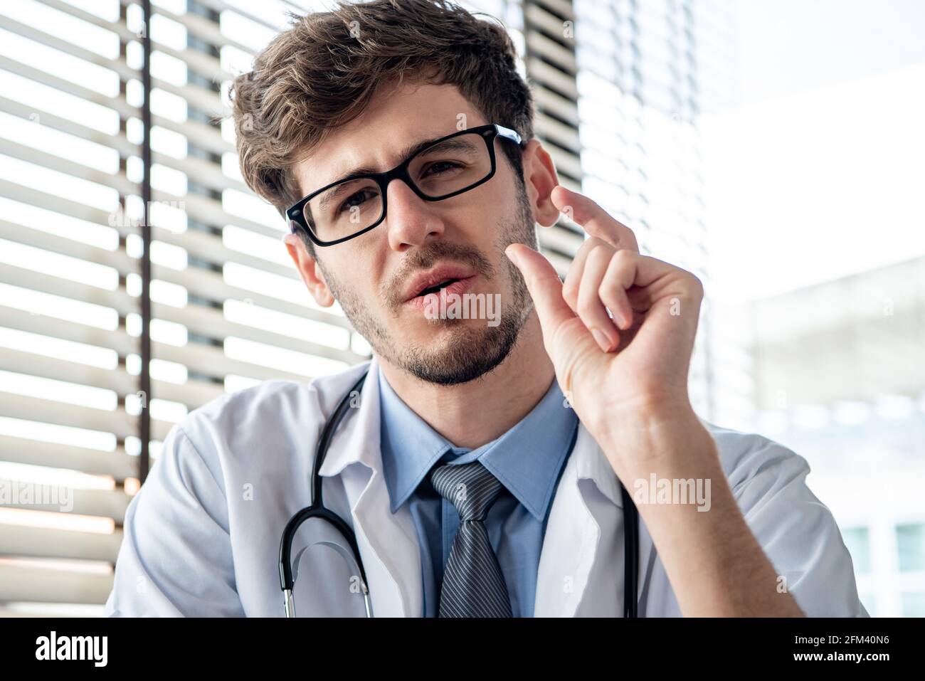 Caucasian male doctor looking at camera explaining patient in video call meeting, online medical consultation and telehealth concepts Stock Photo