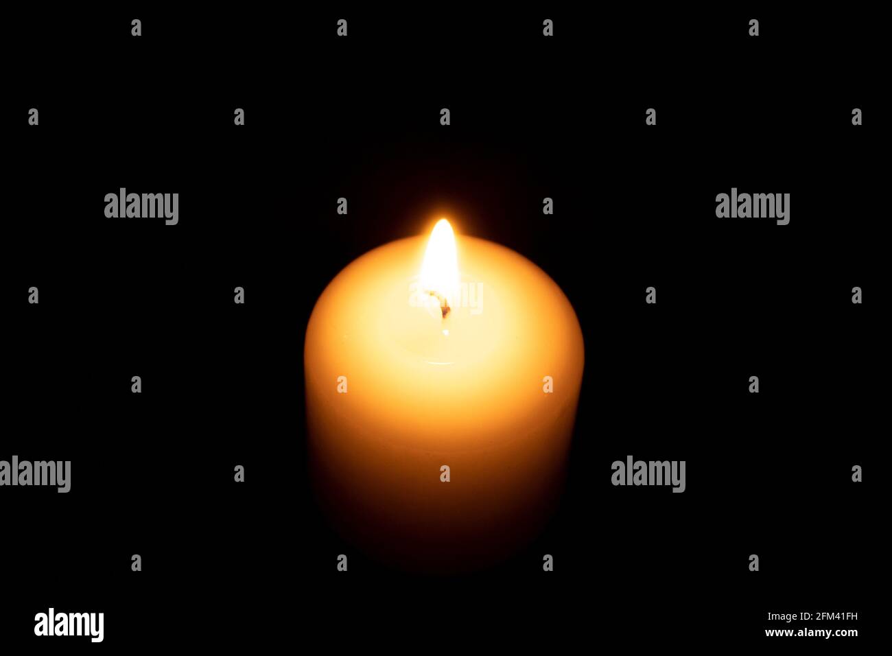 Fire wax candle on a black background. The flame of a burning candle in