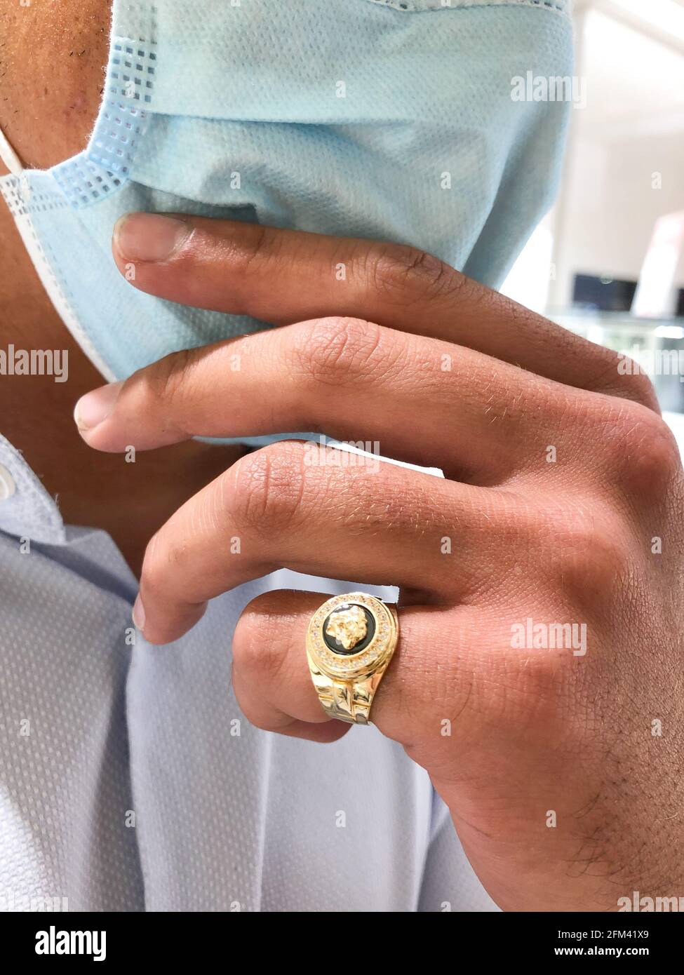 Alicante, Spain - April, 2021: Big gold Versace style ring on young man hand,  wearing face mask Stock Photo - Alamy
