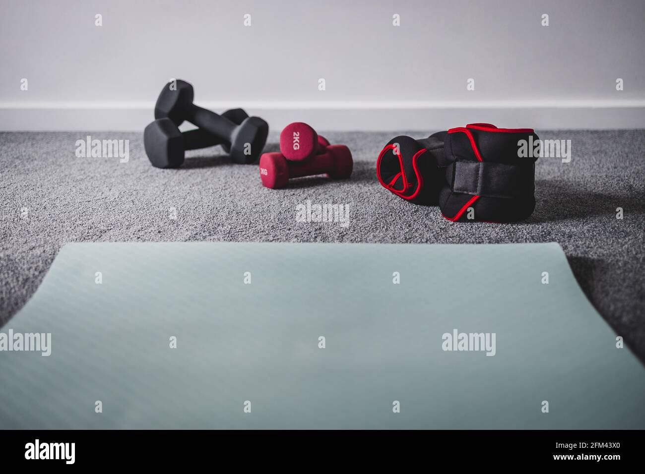 home gym with mixed fitness items including ankle weights and different  sets of dumbbells on the floor Stock Photo - Alamy