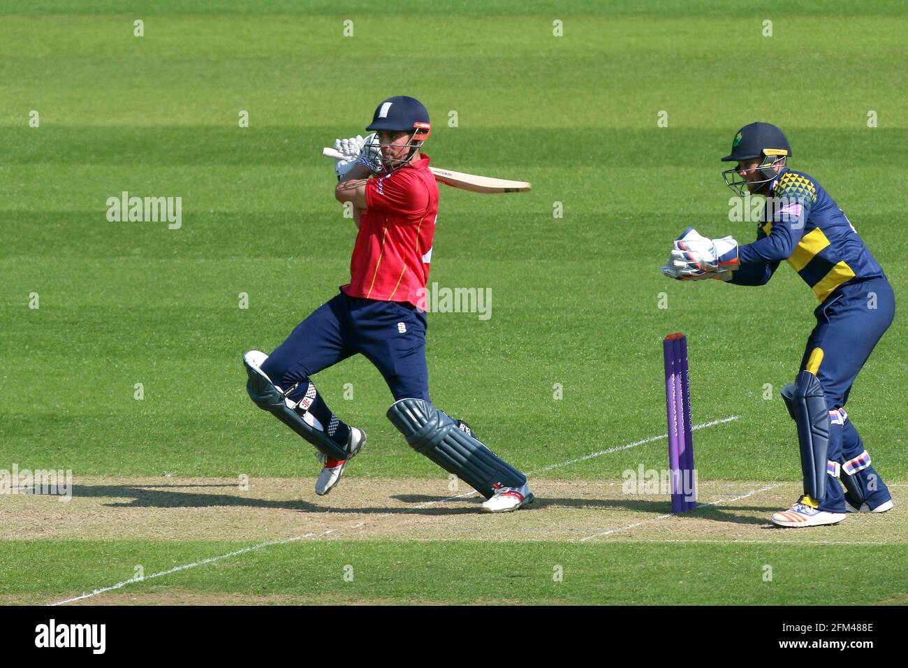 Alastair Cook in batting action for Essex as Chris Cooke looks on from