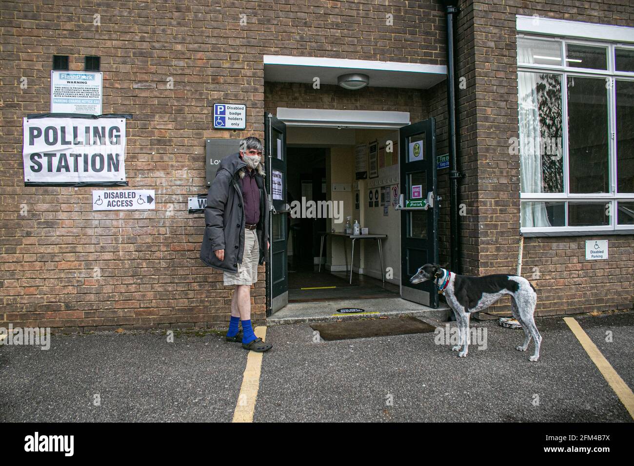 WIMBLEDON LONDON 6 May 2021. A man walks with his dog to the  polling station at the Sacred Heart church in Wimbledon to vote as millions of voters go to the polls on what is known as Super Thursday for the first time in two years  across the country for the London Mayor and to elect  Scottish and Welsh Parliaments, as well as Regional Mayor and  councillors. The local elections were postponed last year due to the coronavirus pandemic. Credit amer ghazzal/Alamy Live News Stock Photo