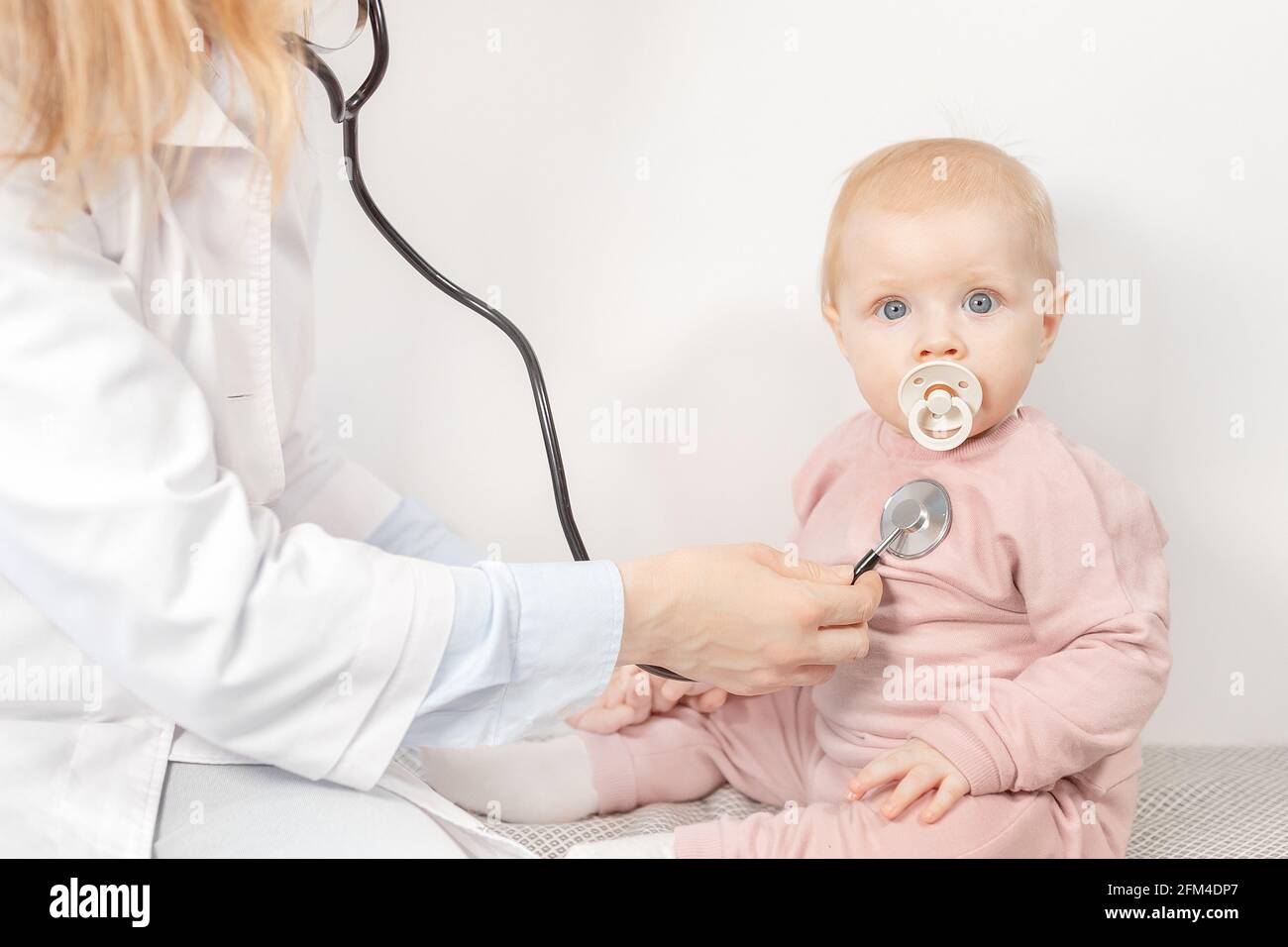 Female pediatrician exam baby girl patient, hold a stethoscope, check heart  and lungs of little child. Woman doctor doing a month check up of cute  Stock Photo - Alamy