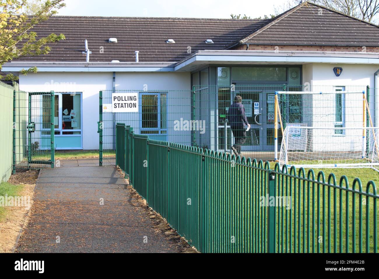 School being used as polling station with rear view of a man about to enter the building Stock Photo